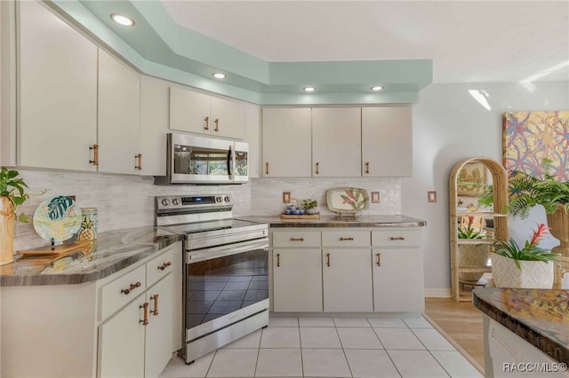 kitchen with white cabinetry, recessed lighting, appliances with stainless steel finishes, light tile patterned floors, and decorative backsplash