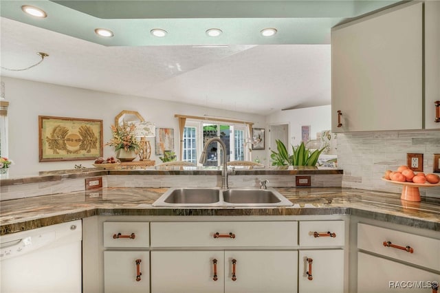 kitchen with recessed lighting, white dishwasher, a sink, decorative backsplash, and white cabinets