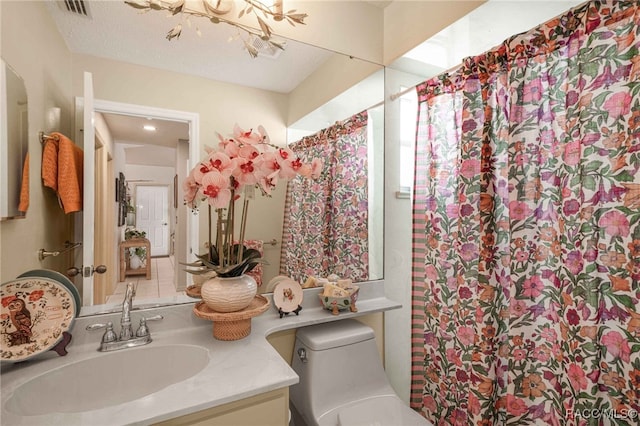 bathroom with a notable chandelier, visible vents, toilet, and vanity