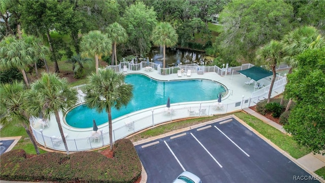 pool with a patio area and fence