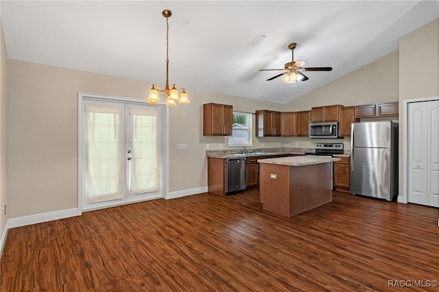 kitchen with appliances with stainless steel finishes, sink, pendant lighting, dark hardwood / wood-style floors, and a kitchen island