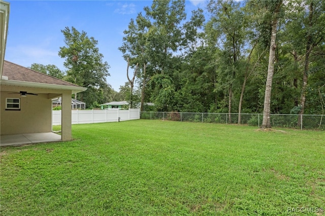 view of yard with ceiling fan and a patio area