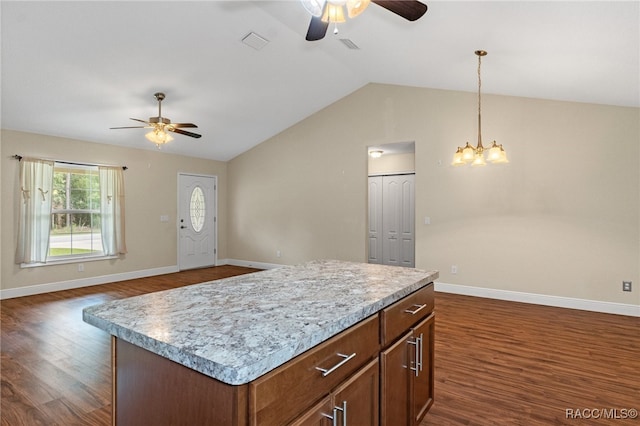 kitchen with pendant lighting, ceiling fan with notable chandelier, vaulted ceiling, a kitchen island, and dark hardwood / wood-style flooring