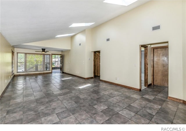 unfurnished room featuring ceiling fan, high vaulted ceiling, and a skylight