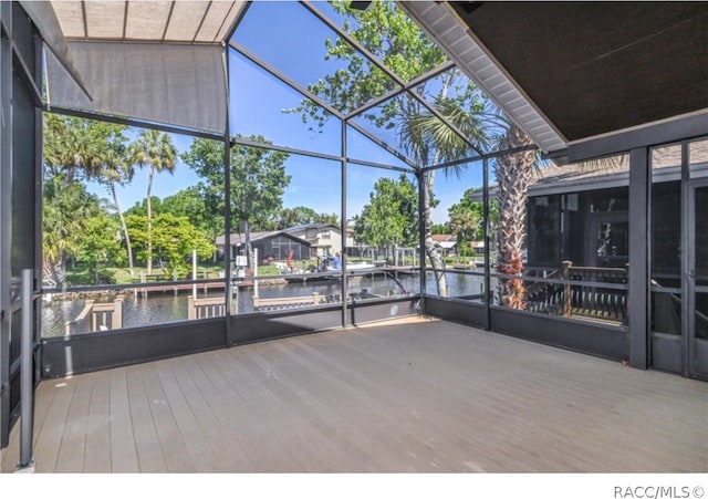 unfurnished sunroom featuring a water view