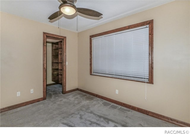 carpeted empty room featuring ceiling fan