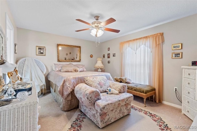 bedroom featuring light carpet, ceiling fan, and baseboards