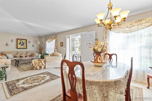 dining room featuring lofted ceiling, carpet floors, and a chandelier