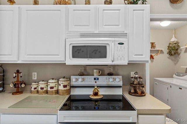 kitchen with white appliances, white cabinetry, and washer and clothes dryer