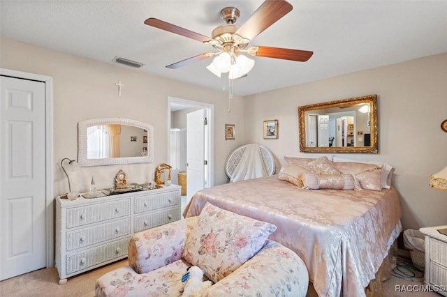 bedroom featuring a ceiling fan, light carpet, connected bathroom, and visible vents