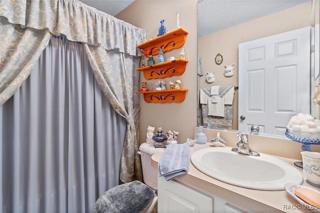 bathroom with vanity, a textured ceiling, and toilet