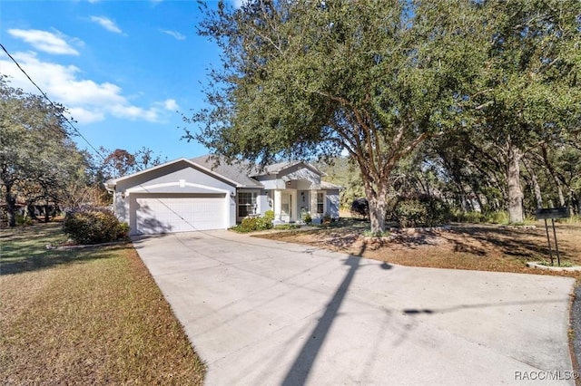 view of front facade with an attached garage, a front yard, concrete driveway, and stucco siding