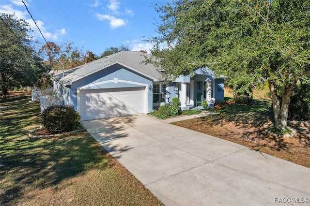 view of front of home with a front yard and a garage