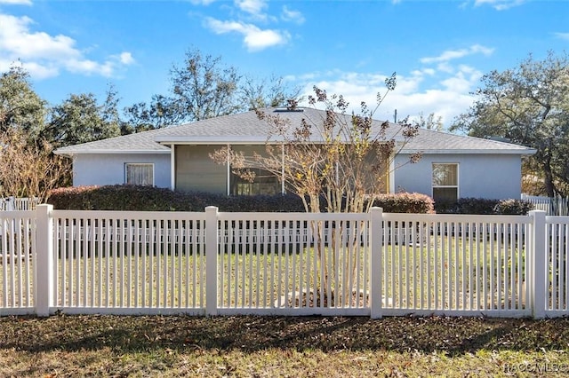 ranch-style home with fence, a front lawn, and stucco siding