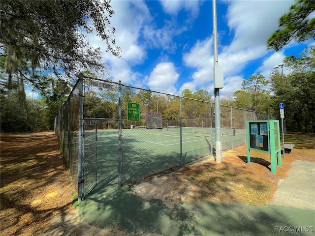 view of tennis court featuring fence