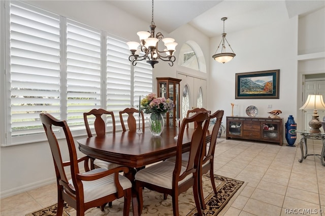 dining area with a chandelier, light tile patterned floors, and a high ceiling