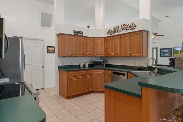 kitchen with kitchen peninsula, sink, and high vaulted ceiling