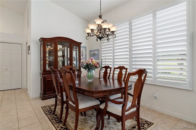 dining space featuring a notable chandelier, light tile patterned floors, and lofted ceiling