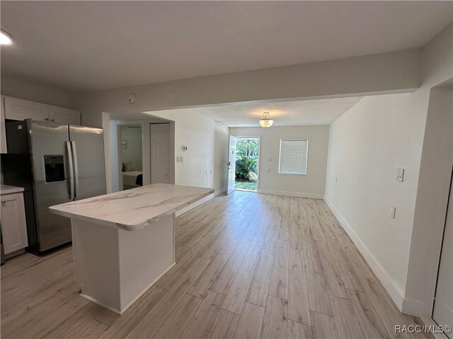 10765 W Spring Cir, Crystal River, FL 34428 - kitchen featuring stainless steel refrigerator with ice dispenser, light wood-type flooring, open floor plan, and a center island