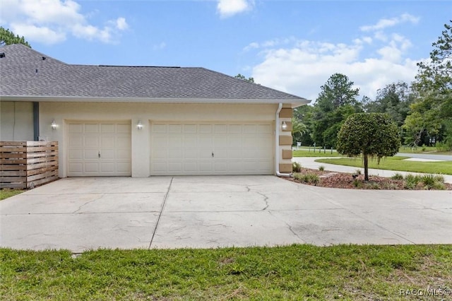 9989 N Langdon Rd, Citrus Springs, FL 34434 - view of property exterior featuring driveway, an attached garage, stucco siding, and a shingled roof