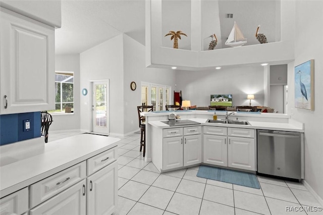 9989 N Langdon Rd, Citrus Springs, FL 34434 - kitchen featuring dishwasher, a peninsula, light tile patterned floors, high vaulted ceiling, and white cabinetry