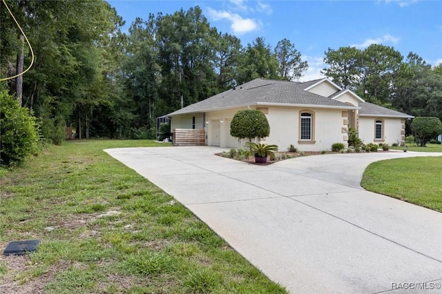9989 N Langdon Rd, Citrus Springs, FL 34434 - view of front of home featuring concrete driveway, a front yard, stucco siding, a garage, and a shingled roof