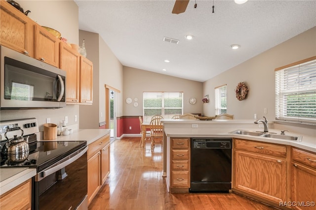 5694 W Hunters Ridge Cir, Lecanto, FL 34461 - kitchen featuring stainless steel appliances, vaulted ceiling, a sink, light countertops, and light wood finished floors