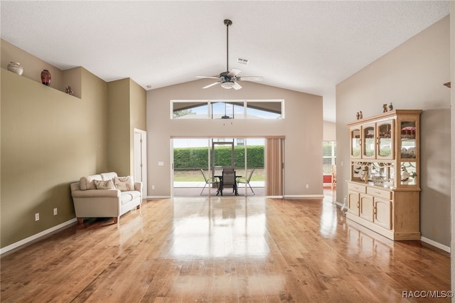 5694 W Hunters Ridge Cir, Lecanto, FL 34461 - living area with light wood-type flooring, high vaulted ceiling, ceiling fan, and baseboards