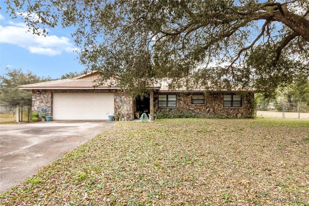 single story home featuring a garage and a front lawn