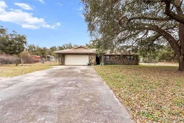 ranch-style house featuring a garage and a front lawn