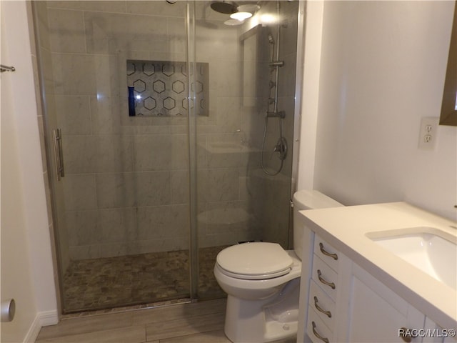 bathroom featuring vanity, toilet, and a shower with door