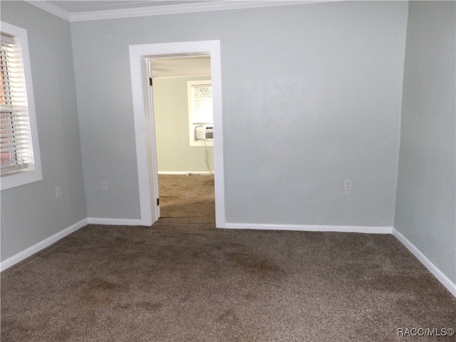 spare room with dark colored carpet, cooling unit, and crown molding