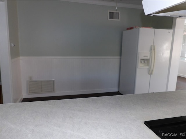kitchen with white fridge with ice dispenser and ornamental molding