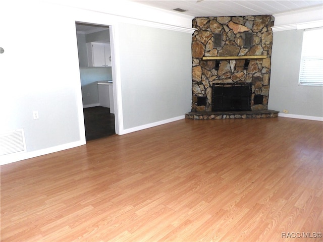 unfurnished living room with wood-type flooring, a stone fireplace, and wood ceiling