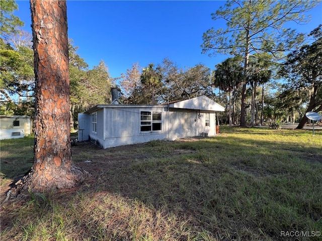 view of side of home with a lawn