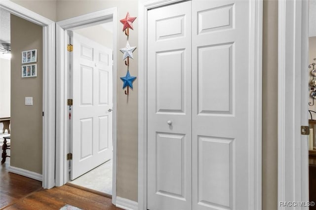 hall featuring baseboards and wood finished floors