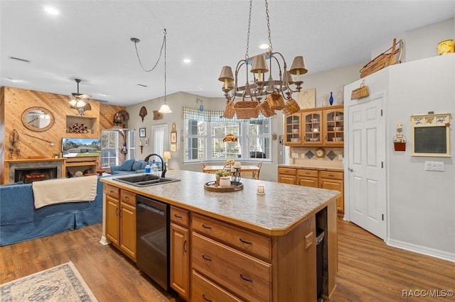 kitchen featuring dark wood-style flooring, a sink, a lit fireplace, light countertops, and dishwasher