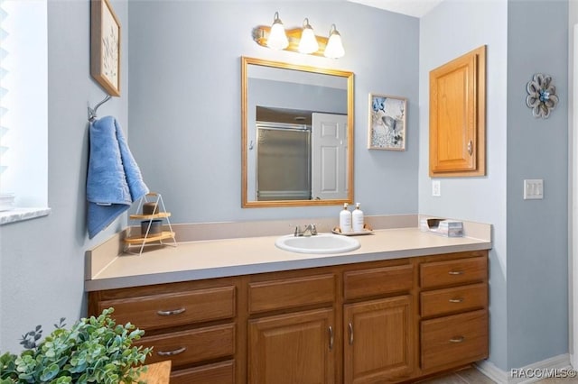 bathroom with a shower with door and vanity