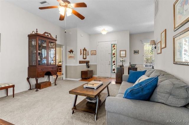 carpeted living area with baseboards, visible vents, and a ceiling fan