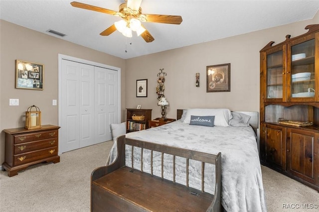 bedroom with a closet, carpet, visible vents, and a ceiling fan