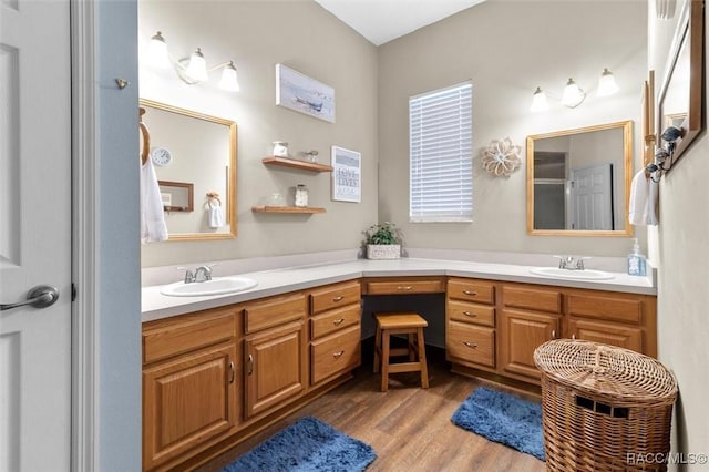 bathroom with double vanity, wood finished floors, and a sink