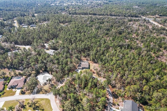 bird's eye view with a wooded view