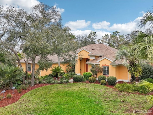 mediterranean / spanish home with a front lawn and stucco siding