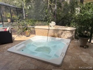 view of pool with a lanai and an outdoor hot tub