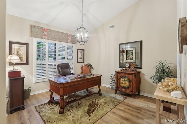 home office with baseboards, visible vents, light wood-style flooring, vaulted ceiling, and a chandelier