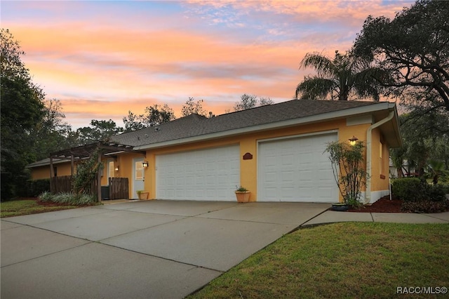 single story home with stucco siding, concrete driveway, an attached garage, and fence