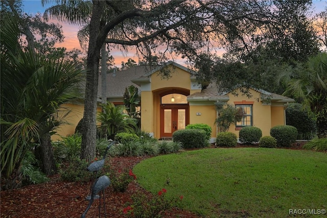 mediterranean / spanish-style home featuring stucco siding and a front lawn