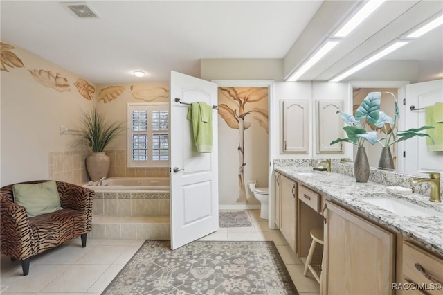 bathroom with a sink, toilet, double vanity, and tile patterned flooring