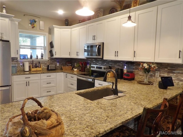 kitchen featuring light stone countertops, pendant lighting, and stainless steel appliances