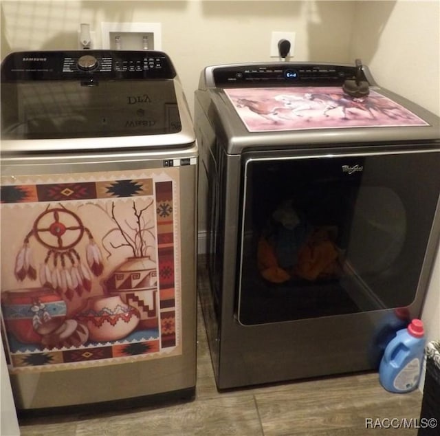 laundry area with washing machine and dryer and hardwood / wood-style flooring